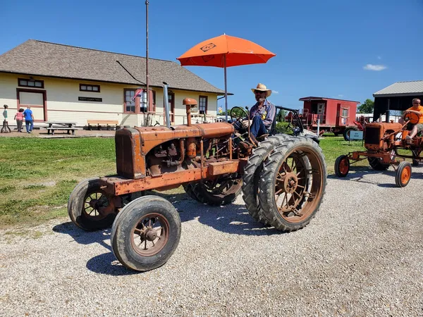 man riding vintage ac tractor