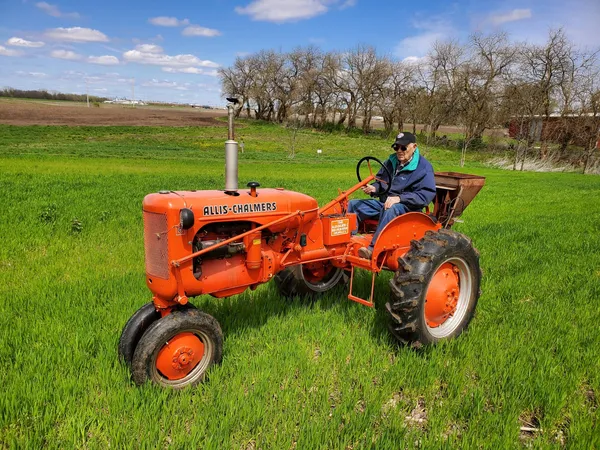 old man on ac tractor